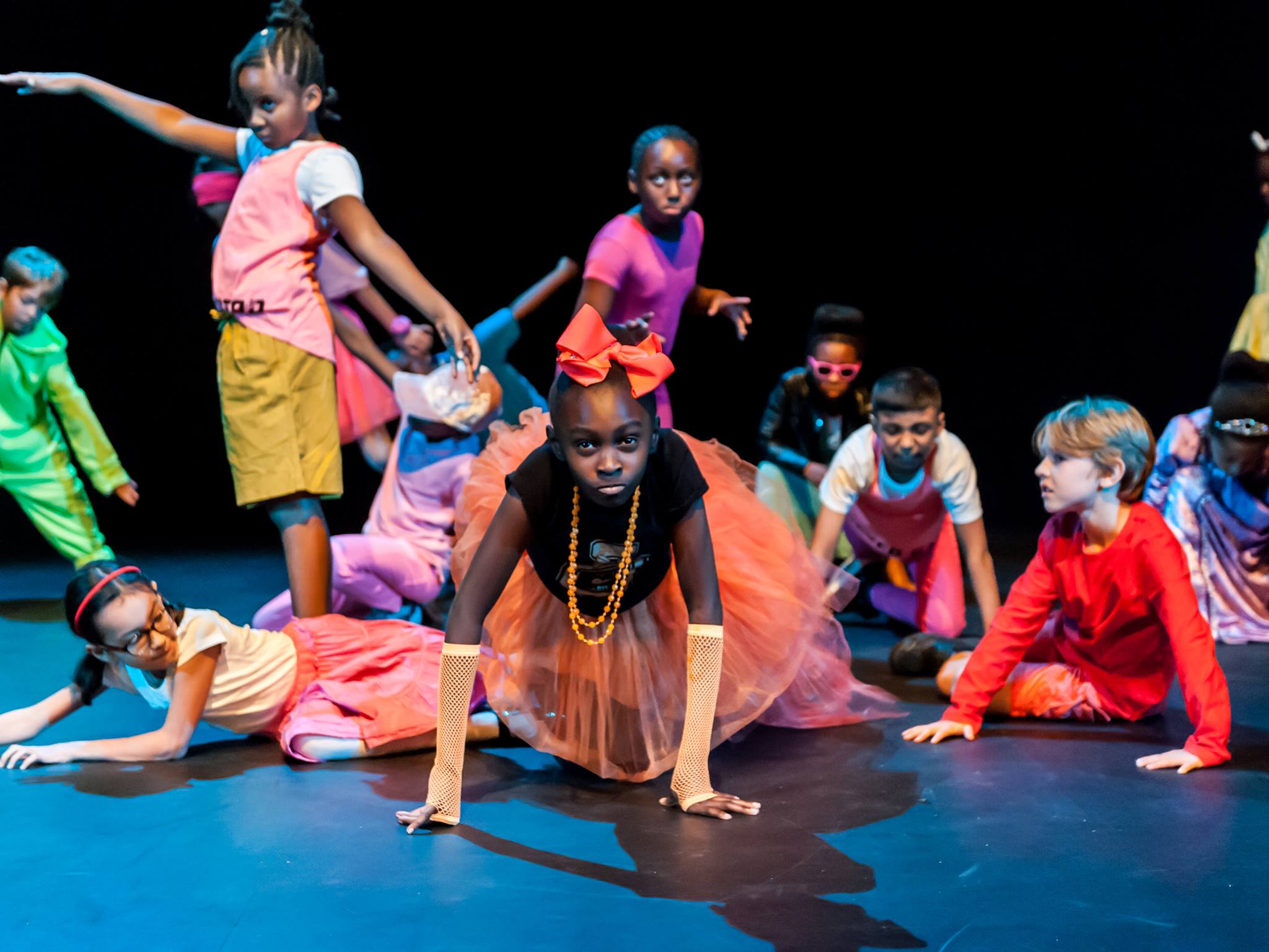 Children perform on a theatre stage.