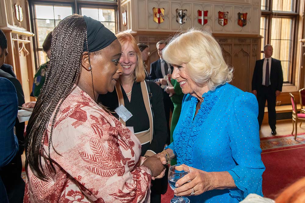 Michelle Ejueyitchie meeting and shaking hands with HM The Queen. Both are smiling.
