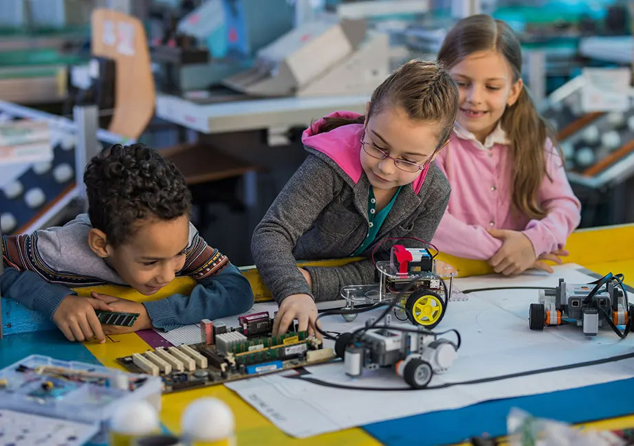 Smiling children experiment with electronics.